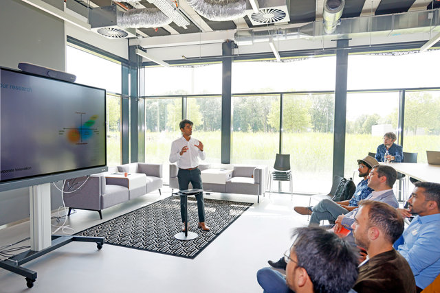 Man stands in bright open space with many windows to present to public