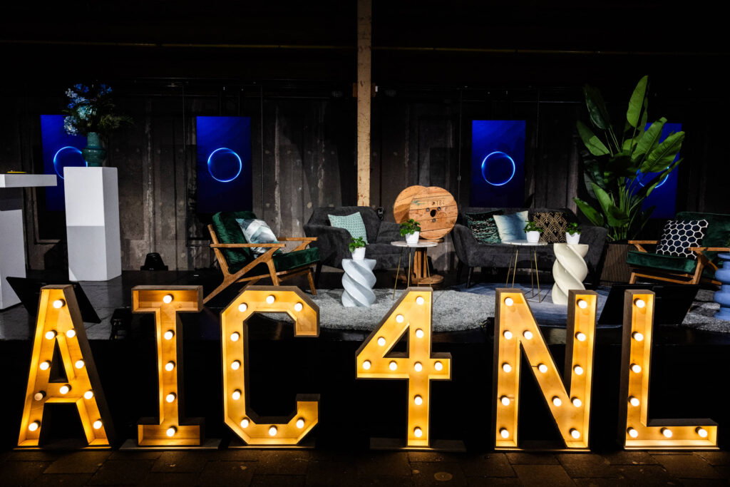 Verlichte AIC4NL letters voor het podium van Het Nederlandse AI Congres.